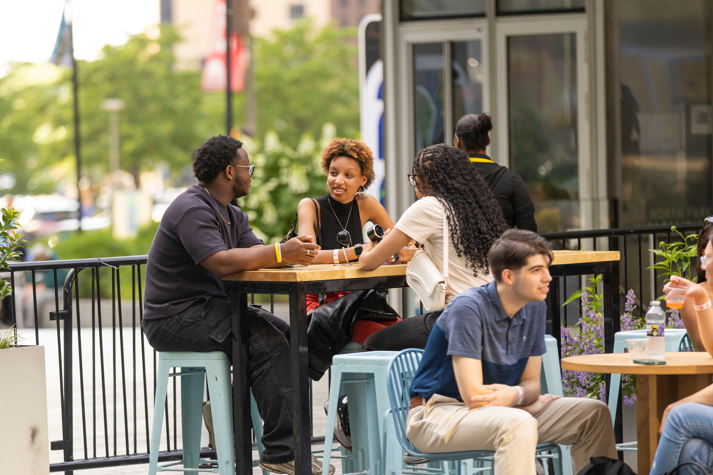 People enjoying happy hour at Dilworth Park. Sitting at a table in a group setting.